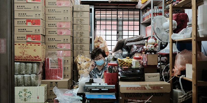 Old Chinese lady supplier answering call in her shop