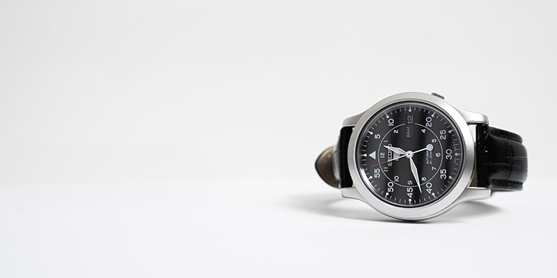 Luxury analog watch on a plain surface