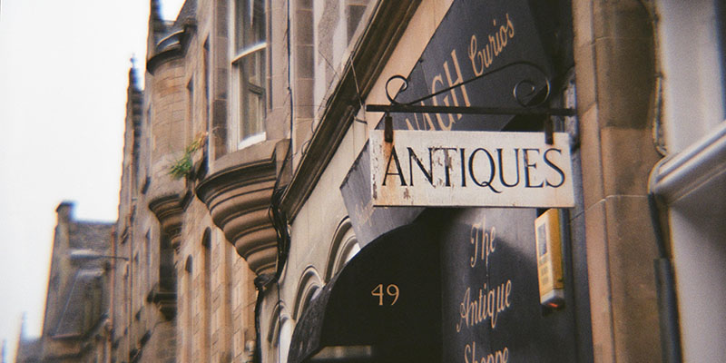 A shop sign saying Antiques in Edinburgh UK