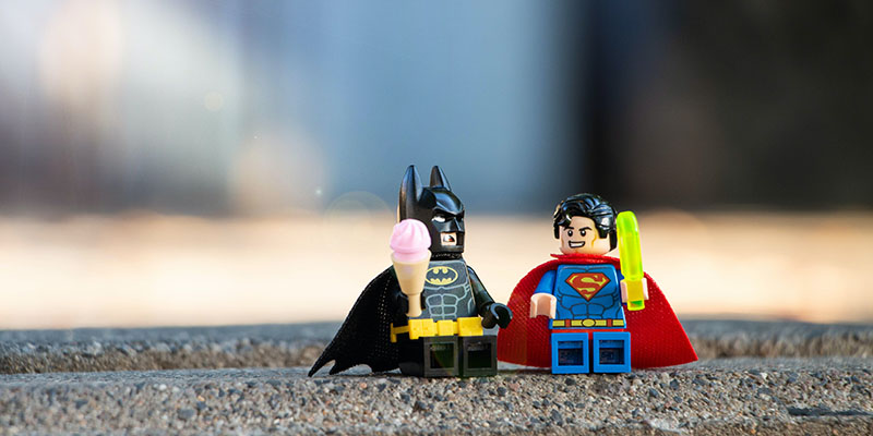 Batman and Superman lego placed on a curb