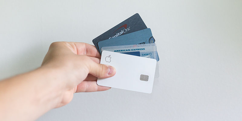 Person holding various credit cards