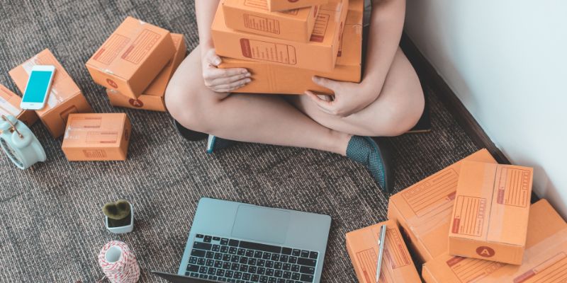 woman packing boxes while sitting on the floor