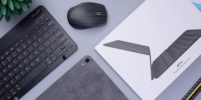 keyboard, mouse, ipad, and ipad cover on a computer desk