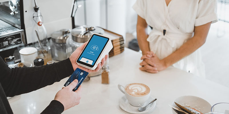 Cashier using card to make pyament using point of sale system