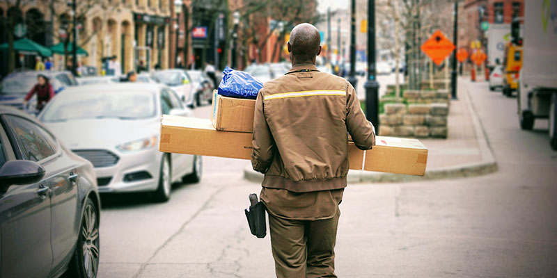 Delivery man in a brown uniform delivering packages