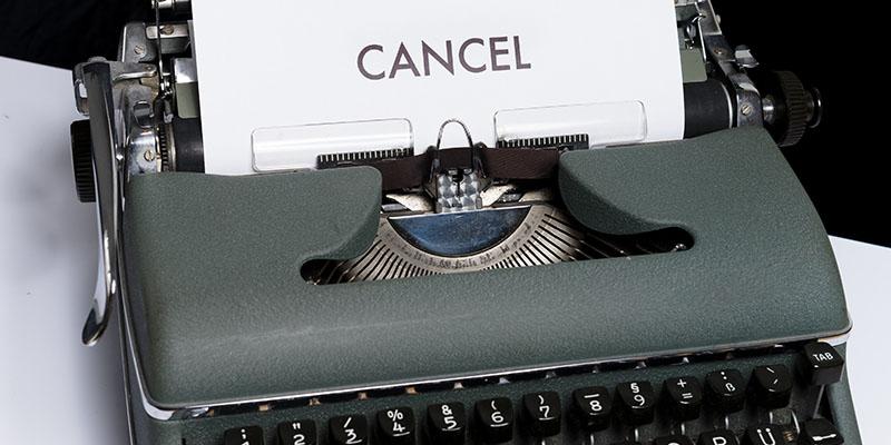 White paper with the word CANCEL typed using a green typewriter