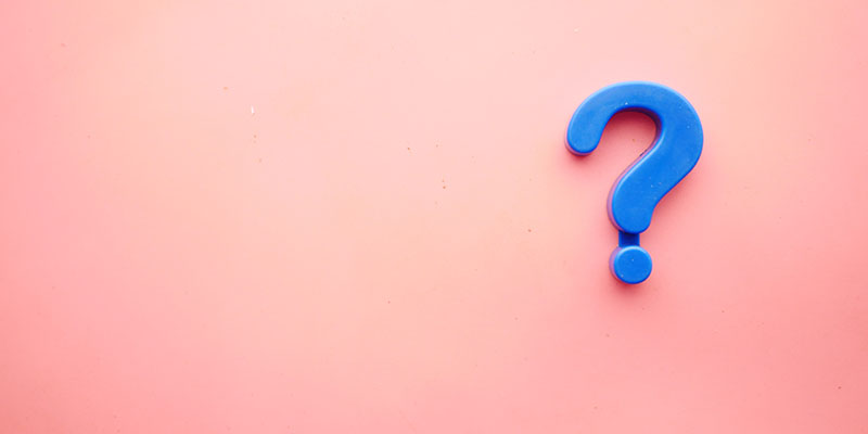 Blue question mark on a peach background