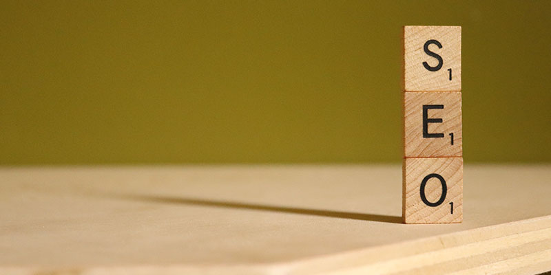 Three scrabble tiles on a wooden table