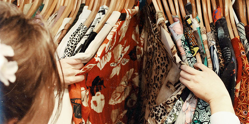 A woman checking out clothes on a rack