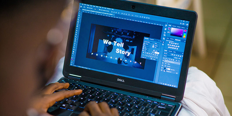A person creating a presentation on a Dell laptop