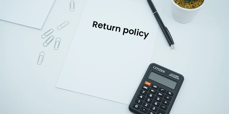 A financial themed photo featuring a blank paper on a desk next to a pen and calculator.