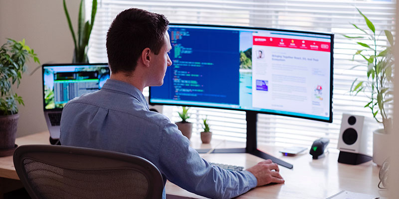 A man working on a two screen workspace