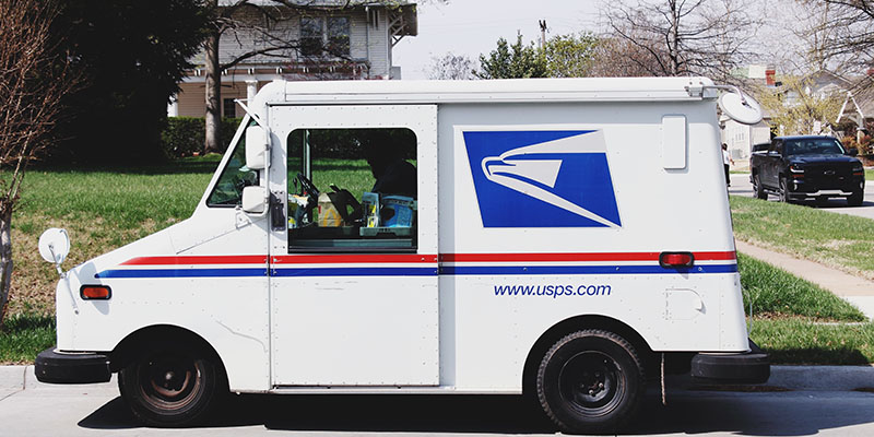 USPS van parked in front of a suburban home