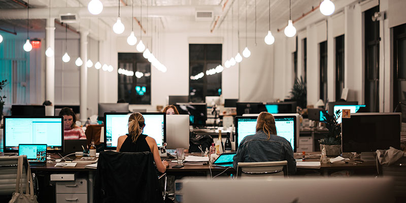 Employees working on their desks in a large open space office