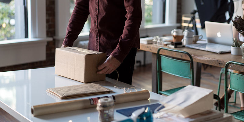 A man packing a box on a table