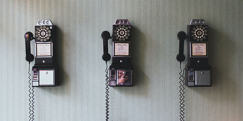 Three vintage telephones on a wall