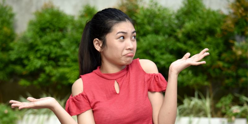 woman holding her hands up appearing undecided