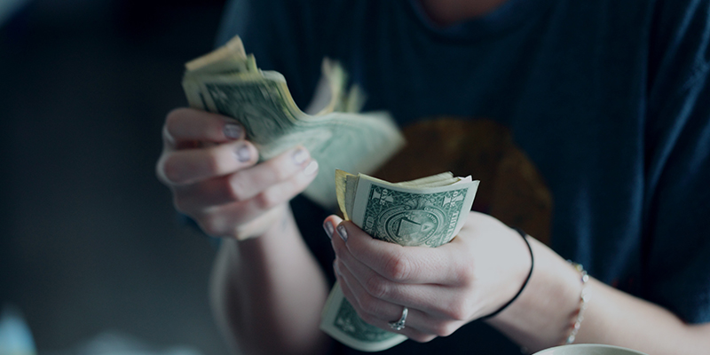 A closeup shot of a woman counting dollar bills