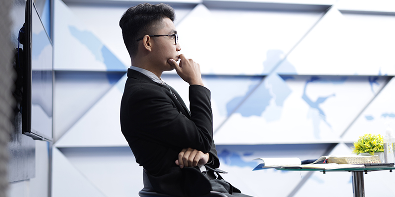 A side profile of a man sitting on a chair thinking