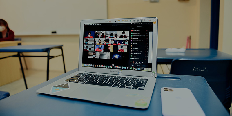 A laptop showing a Zoom meeting of students