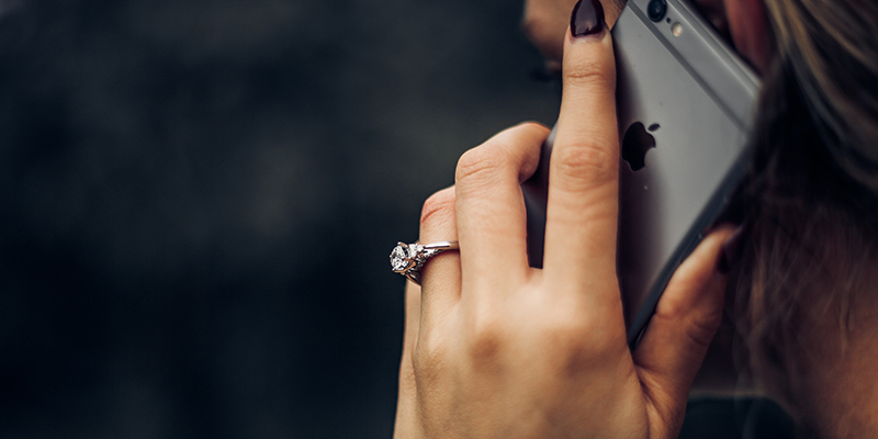 A backside shot of a woman speaking on an iPhone