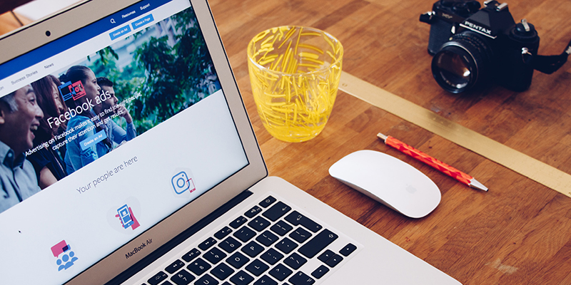 A shot of a laptop on a desk with a Facebook Ads tab opened