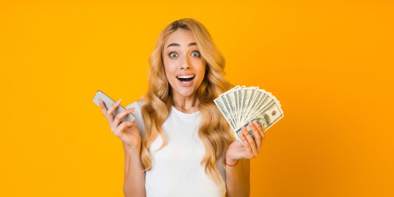 woman holding a mobile phone and cash