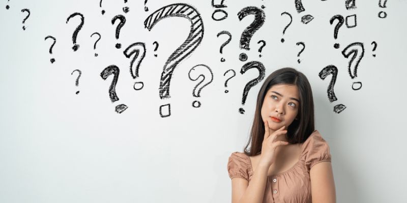 woman with a thoughtful expression with question marks superimposed in background