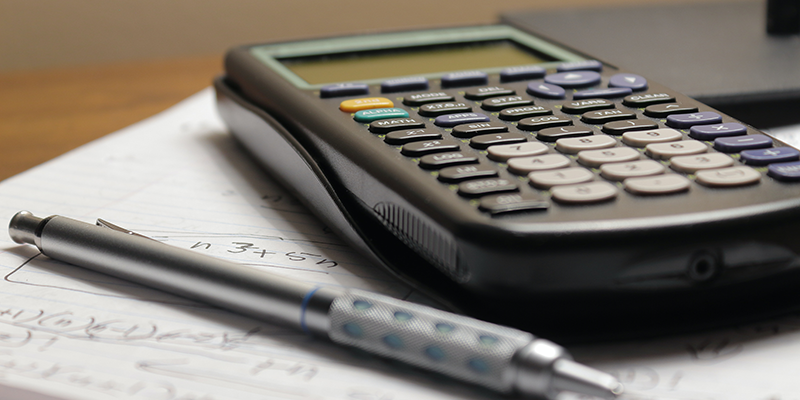 A calculator and a pen on a white book