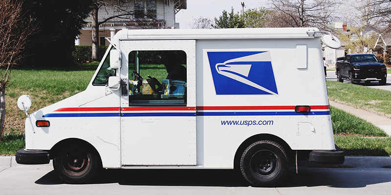 USPS delivery van in a suburban neighborhood