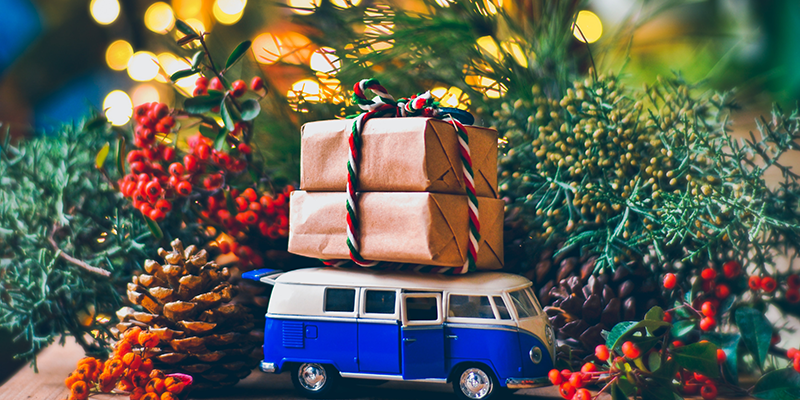 A toy van with Christmas gifts and wreath in the background