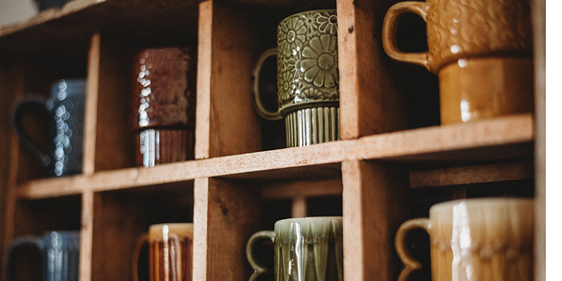 Sets of coffee mugs in a cabinet