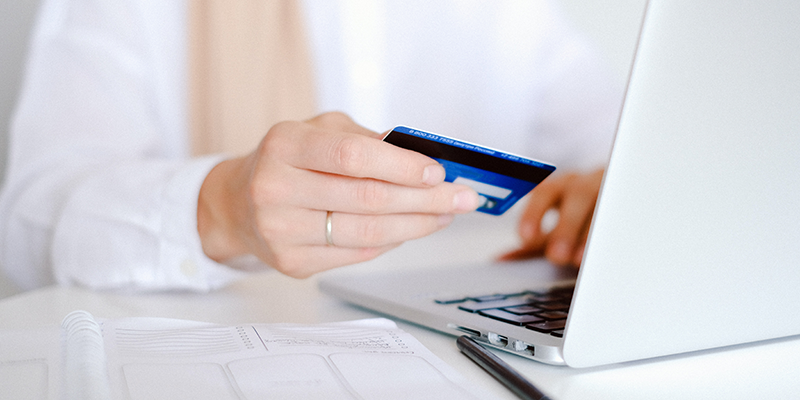 Person in white Long sleeve shirt holding credit card