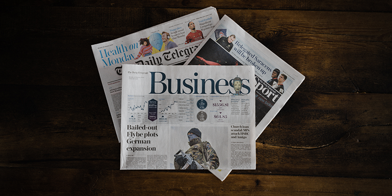 Business section of newspapers on a wooden desk