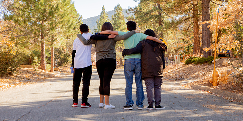 Four groups of friends with their arms on each other