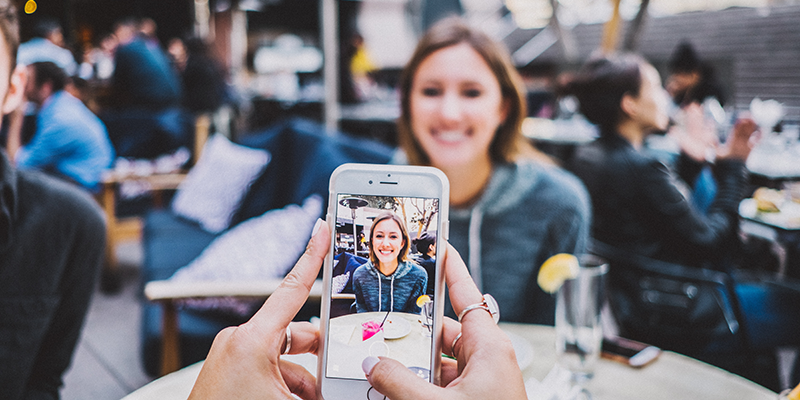 A person taking a picture from a phone of a social media influencer