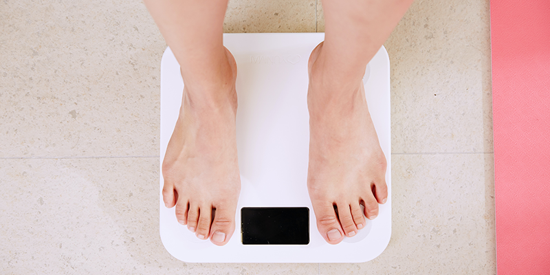 A person standing on a digital weighing machine
