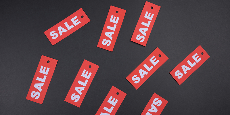 Red color "Sale" labels placed on a black table
